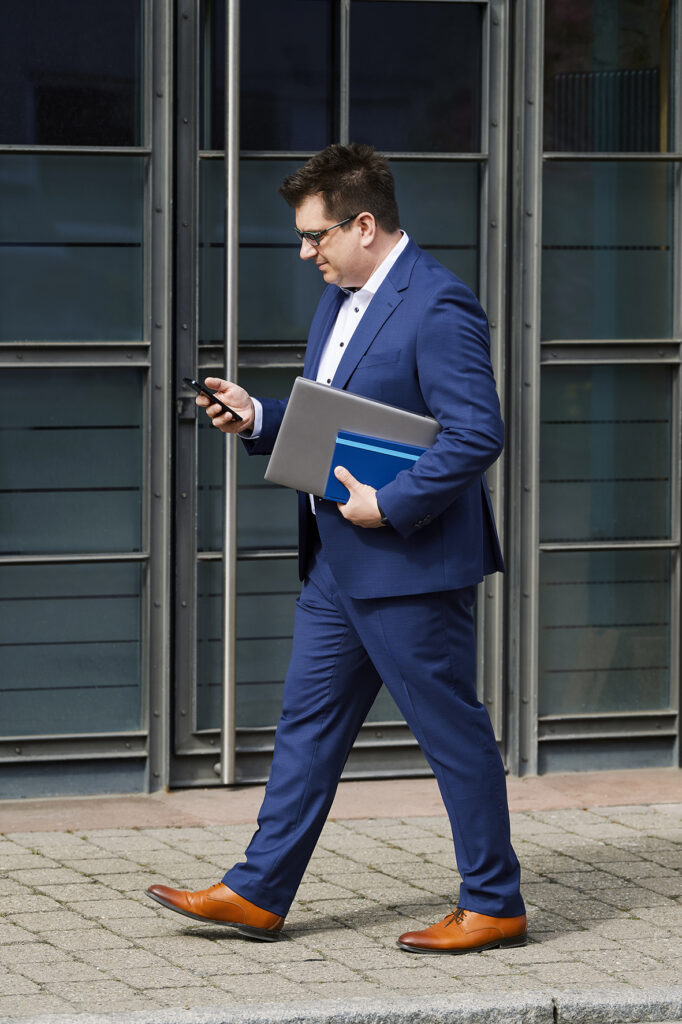 Volker Beck, freier Journalist, in der Hand ein Smartphone, Laptop und Kalender.
